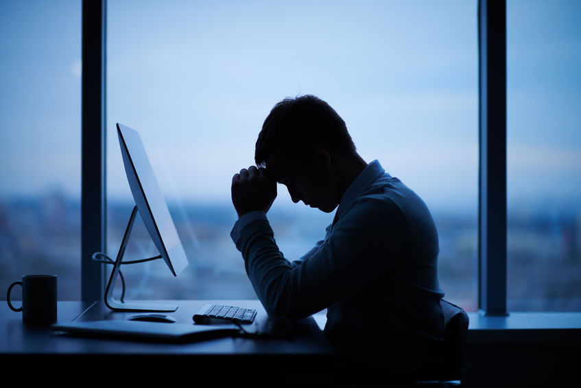 Man with his head bowed, representing the aftermath of a cyberattack and the need for a cyber breach response plan